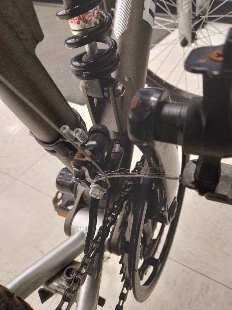 Frayed front derailleur cable on a mountain bike for sale at a thrift store.